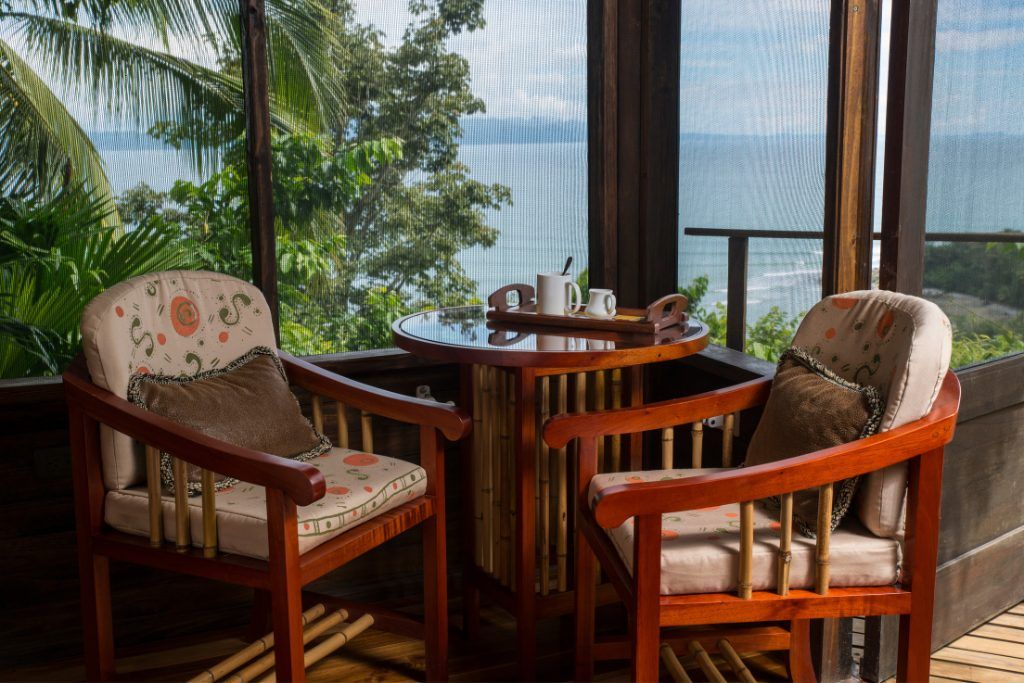 A small table with tea overlooking the Osa Peninsula at Lapa Rios Ecolodge.