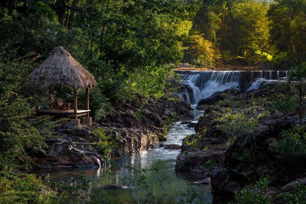 A gazebo overlooking a waterfall at Blancaneaux Lodge.