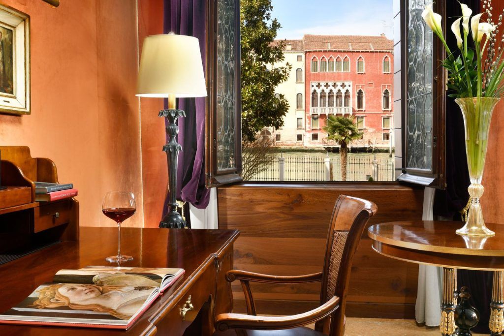 A glass of wine on a table next to a window at the Palazzo Venart.