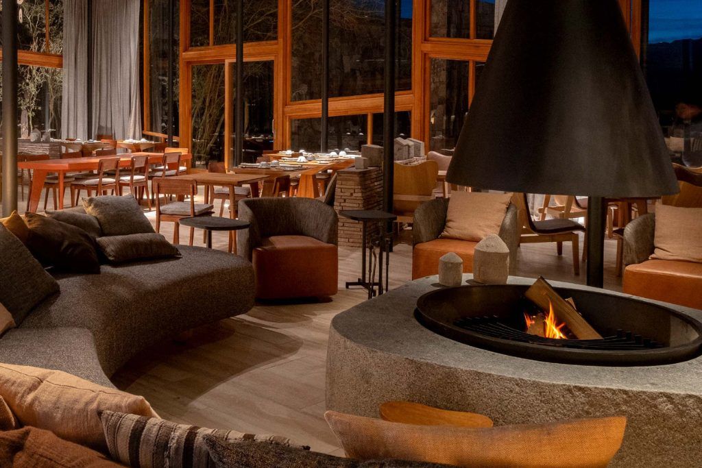 A view of the lounge with a fire burning in the hearth at Tierra Atacama.