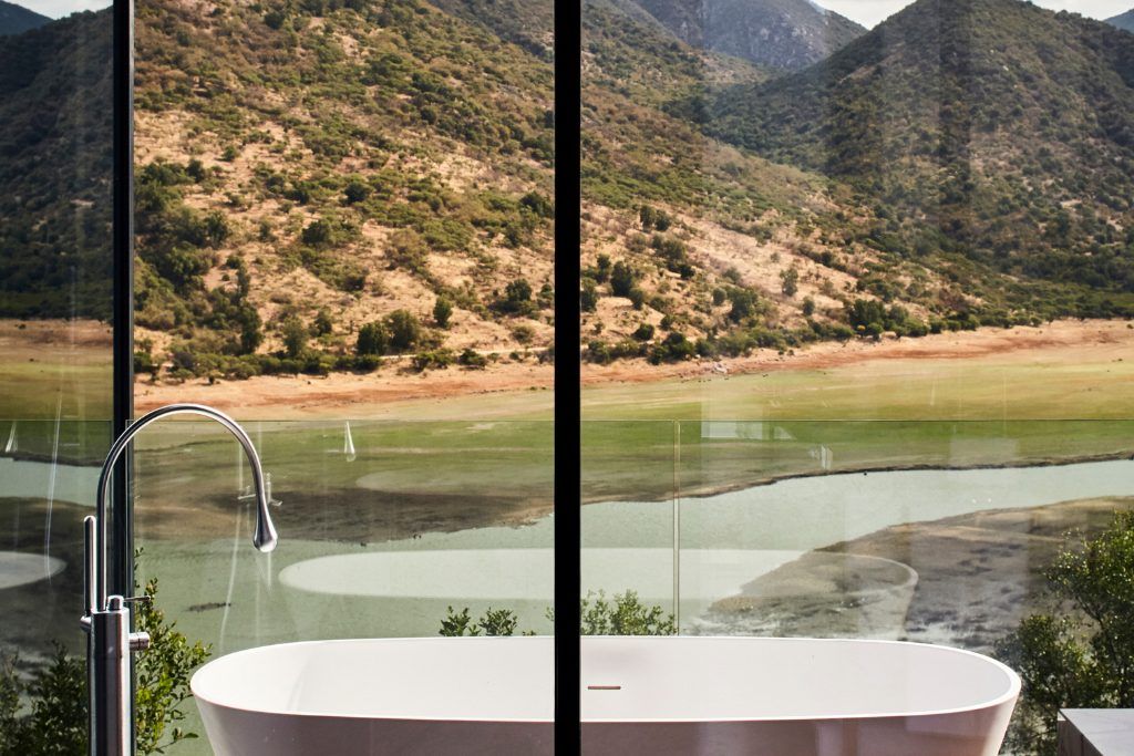 The bathroom next to a panoramic window at Vik Chile.
