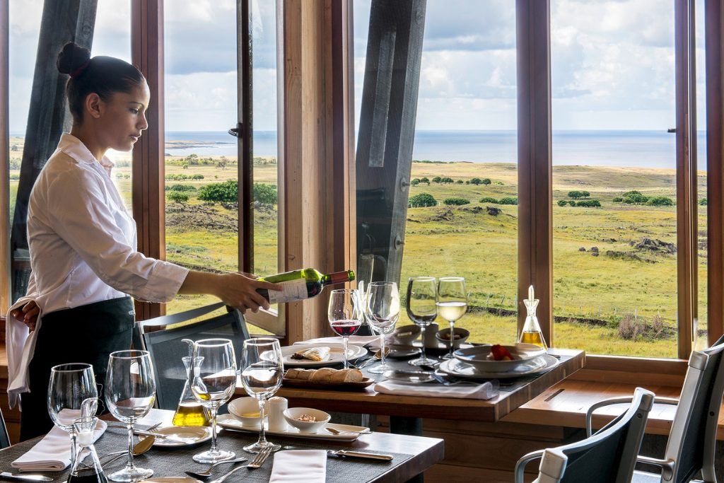 A waiter serving wine in the dining room of Explora Rapa Nui.