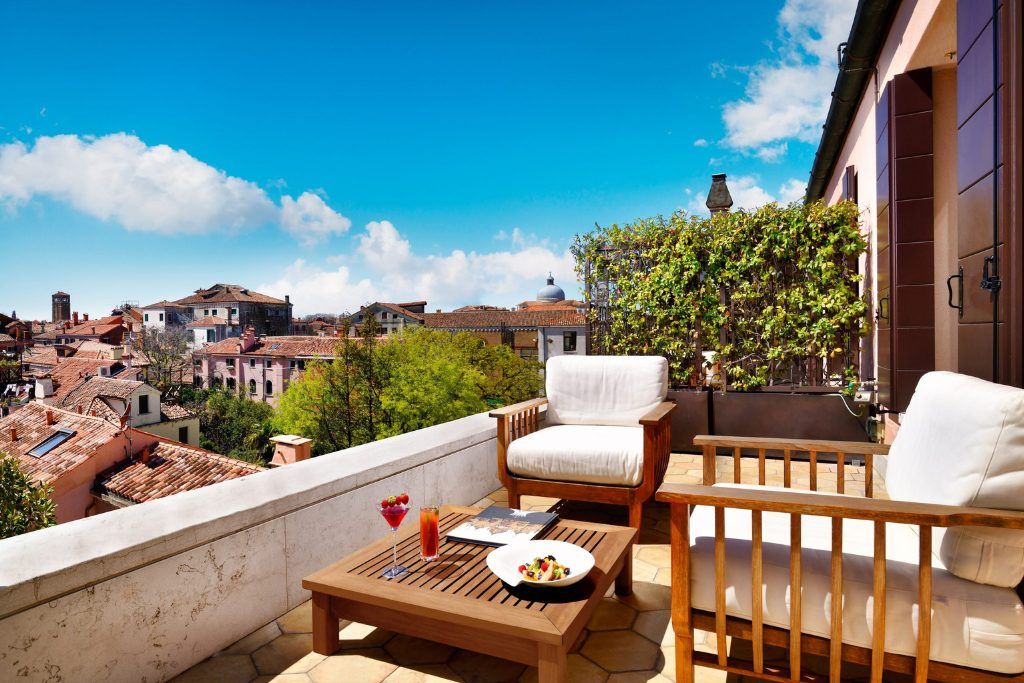 A patio with chairs outside on a sunny day at the Palazzo Venart.