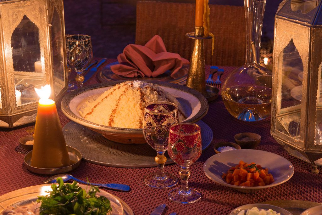 A bowl of rice with side dishes on a table at Dar Ahlam.