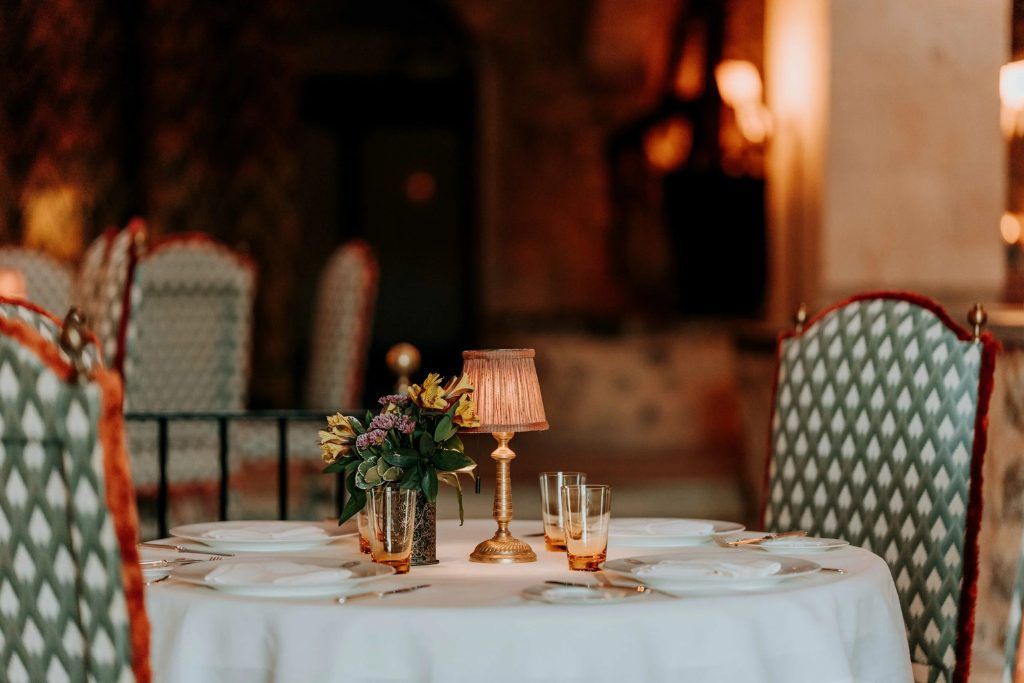 A dining table with a lamp and flowers on it at Grand Hotel Son Net.