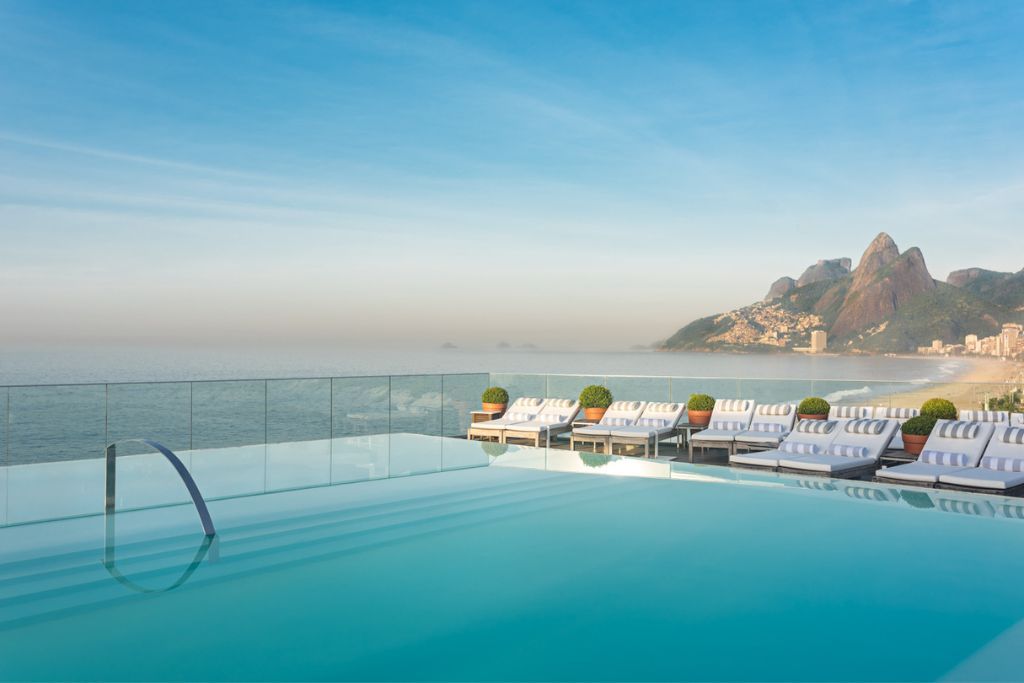 Outdoor rooftop pool with view of sugarloaf mountain and ocean at Fasano Rio