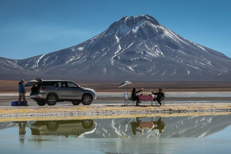 Travelers enjoying a private picnic next to the salt flats in the Atacama Desert during luxury Chile tour