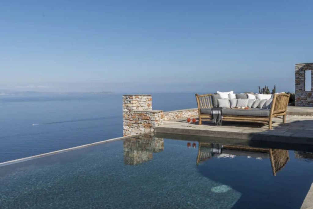 A loveseat next to the infinity pool overlooking the ocean at the Verina Astra hotel