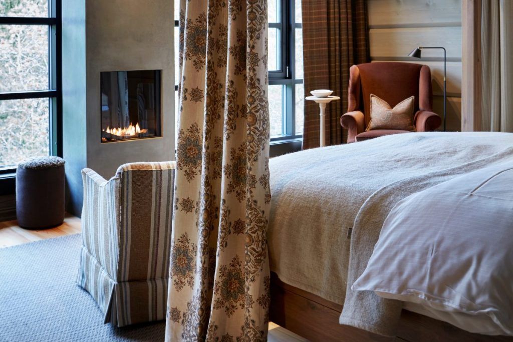 A view of a bed with a fireplace at the foot at Storfjord Hotel.