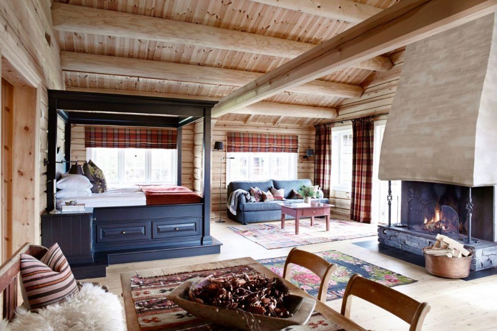 One of the rooms with a fireplace, a living space, a table, and wooden accents at Storfjord Hotel.