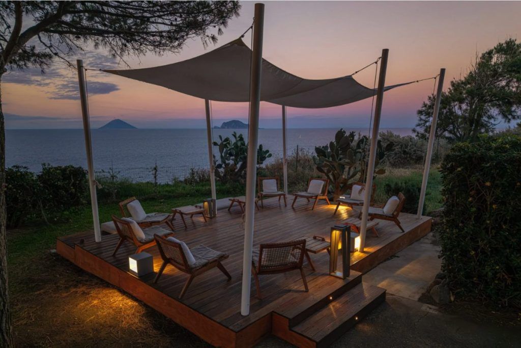 The patio at sunset with chairs under a gazebo at the Capofaro Resort.