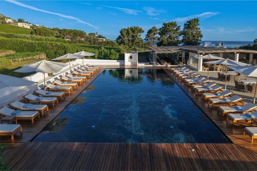 The outdoor swimming pool with loungers around it at Capofaro Resort.