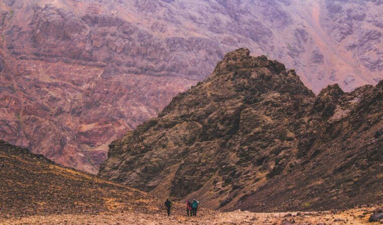 A view of hikers in the red mountains of Toubkal.