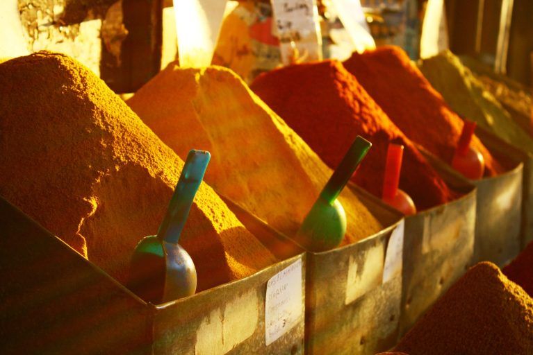 A close-up photo of piles of spices in boxes in the souks of Marrakech.