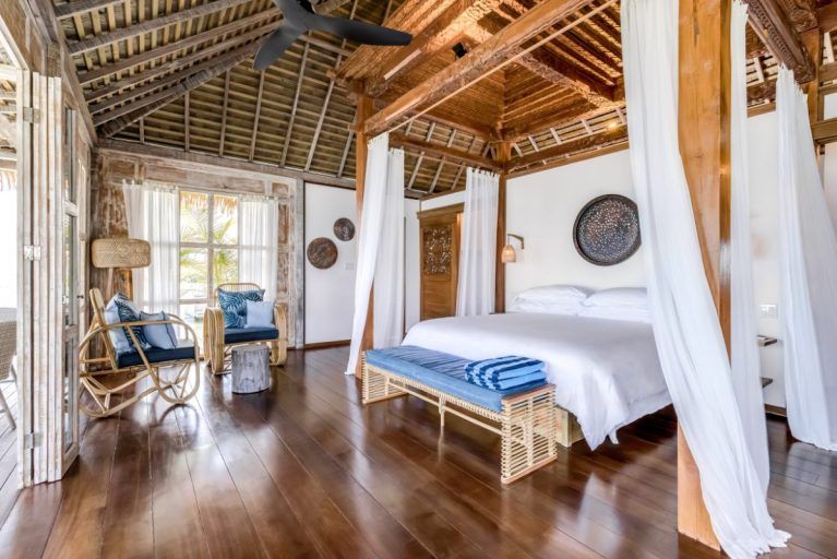 A view of a king bed in a rustic bungalow in Nayara Bocas del Toro.