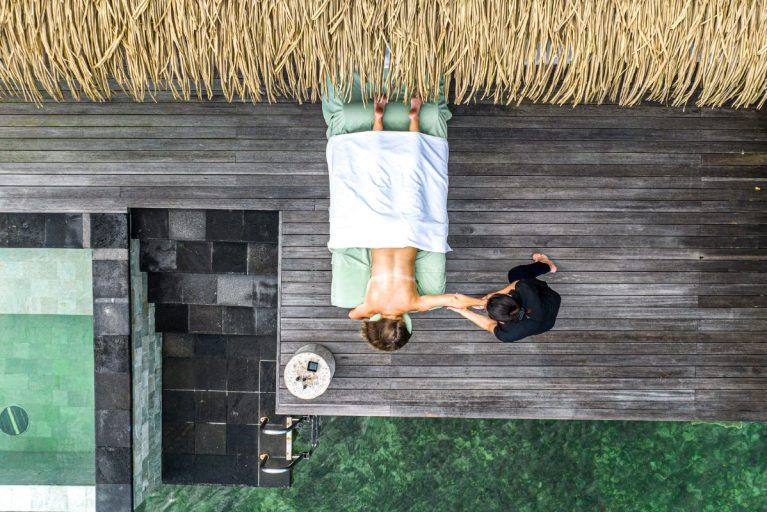 An aerial view of a man receiving a massage in an overwater bungalow in Bocas del Toro.