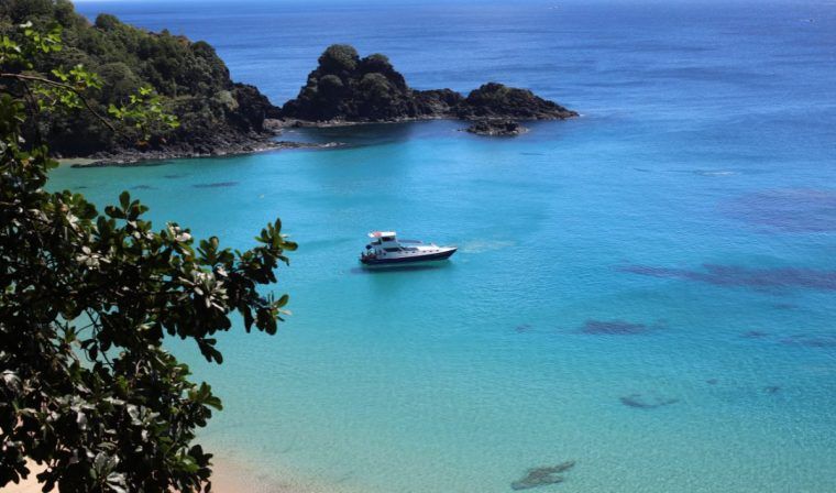 A yacht in the bay of one of the inlets in Fernando de Noronha, Brazil